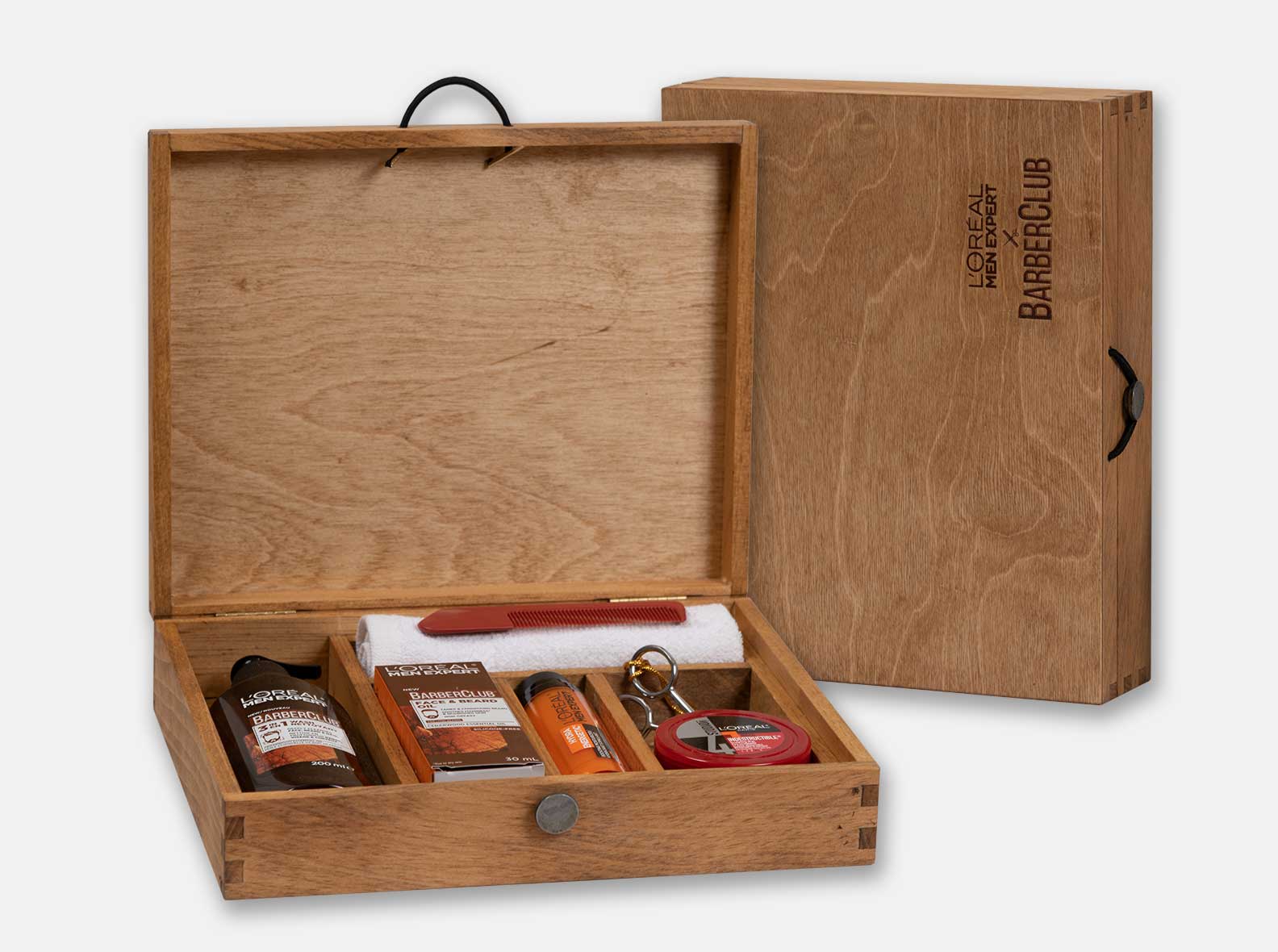 Custom hinged box for L'Oreal grooming products with dividers. Box joint construction. Black Walnut oil finished by hand. Pewter button closure.